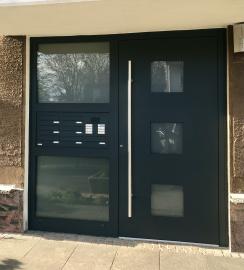 Schwarze Haustür mit Ornamentglas und Klingelanlage