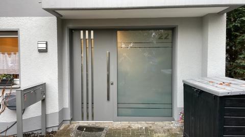 Hellgraue Haustür mit einem breiten Seitenteil